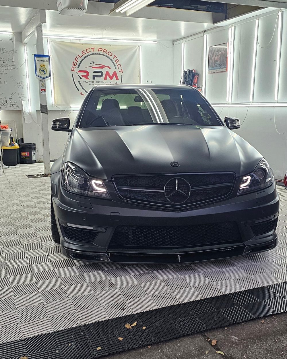 Matte black Mercedes-Benz C-Class in the detailing bay